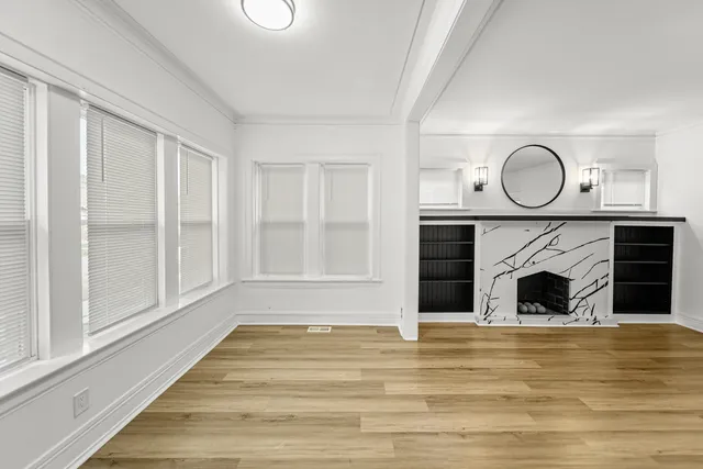 an empty room with wooden floor and windows