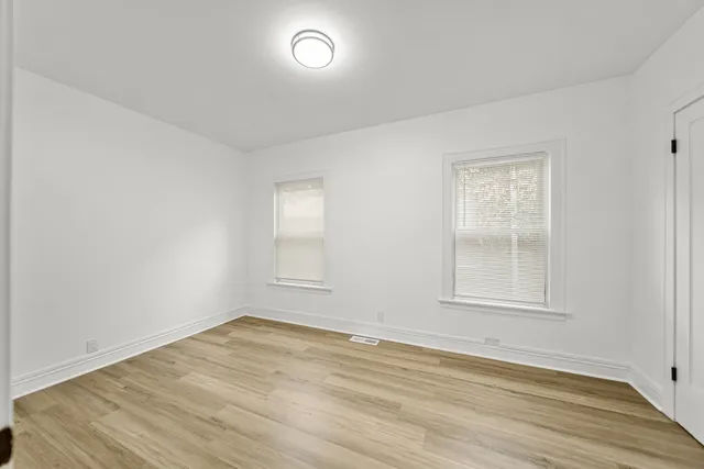 an empty room with wooden floor and sliding door
