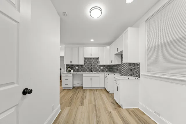 a bathroom with a sink and mirror with bathtub