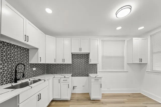 a picture of a room with wooden floor and a potted plant