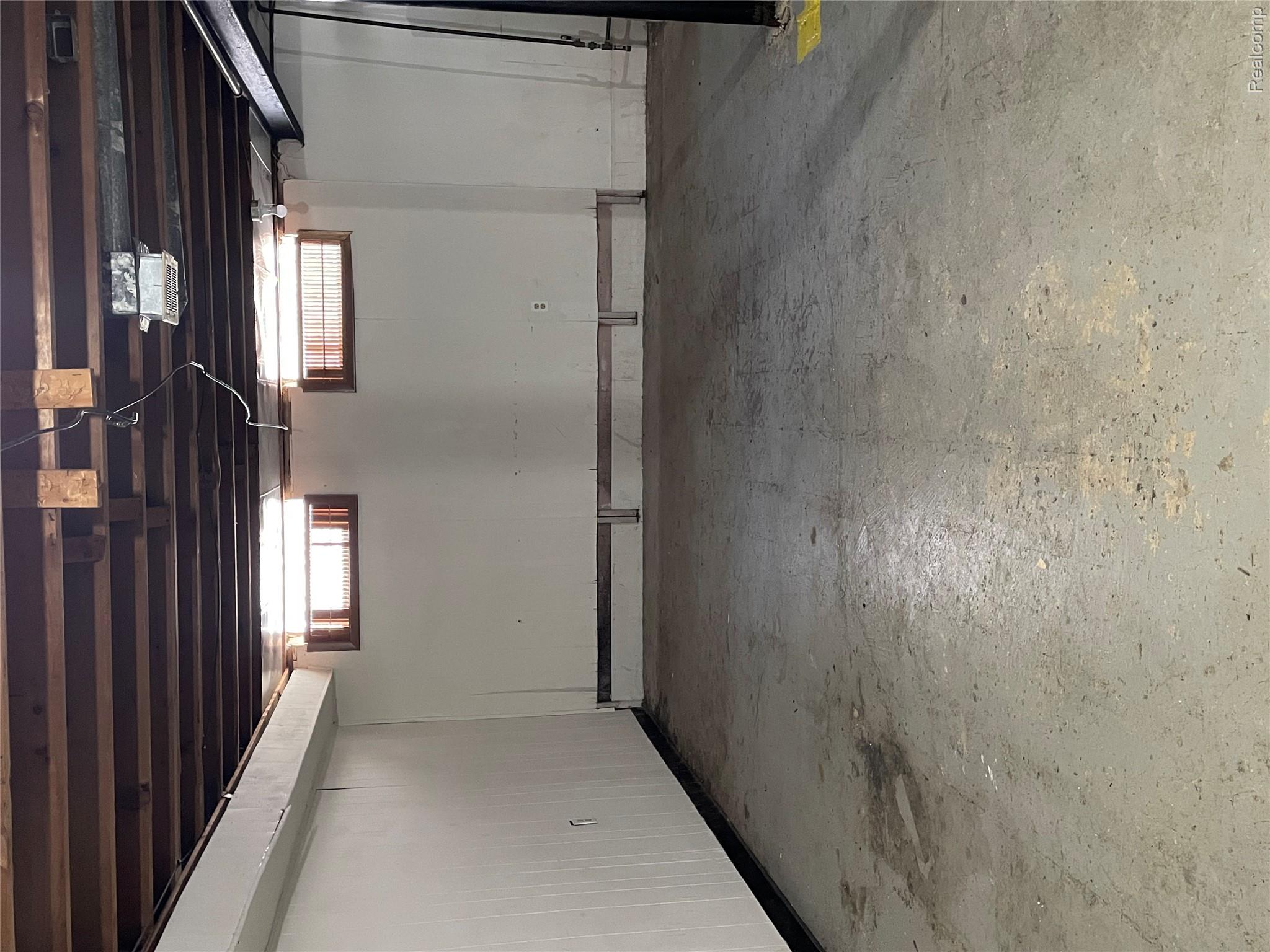 1173 Featherstone Road Pontiac, MI 48342 - Photo 20 of 23 Spacious lower level featuring exposed ceiling joists, concrete flooring, and two transom windows