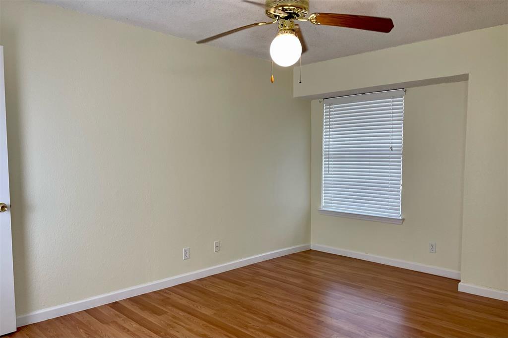 4748 Old Bent Tree Lane, Unit 1404 Dallas, TX 75287 - Photo 15 of 25 a view of an empty room with wooden floor and a window