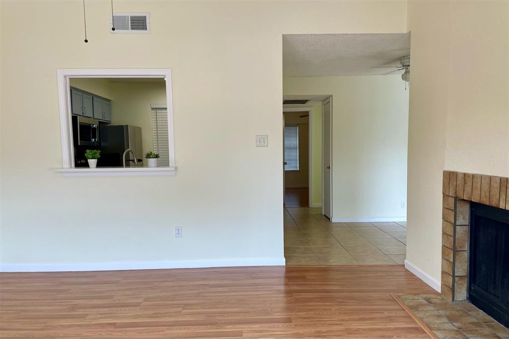 4748 Old Bent Tree Lane, Unit 1404 Dallas, TX 75287 - Photo 5 of 25 a view of a room with wooden floor and a fireplace