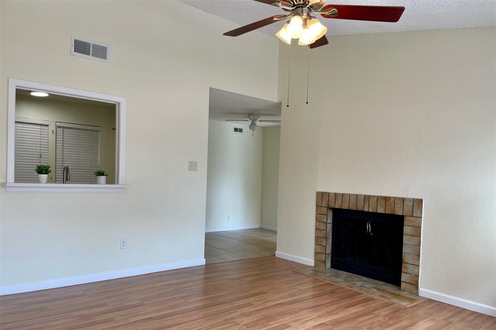 4748 Old Bent Tree Lane, Unit 1404 Dallas, TX 75287 - Photo 6 of 25 a view of an empty room with wooden floor and a window