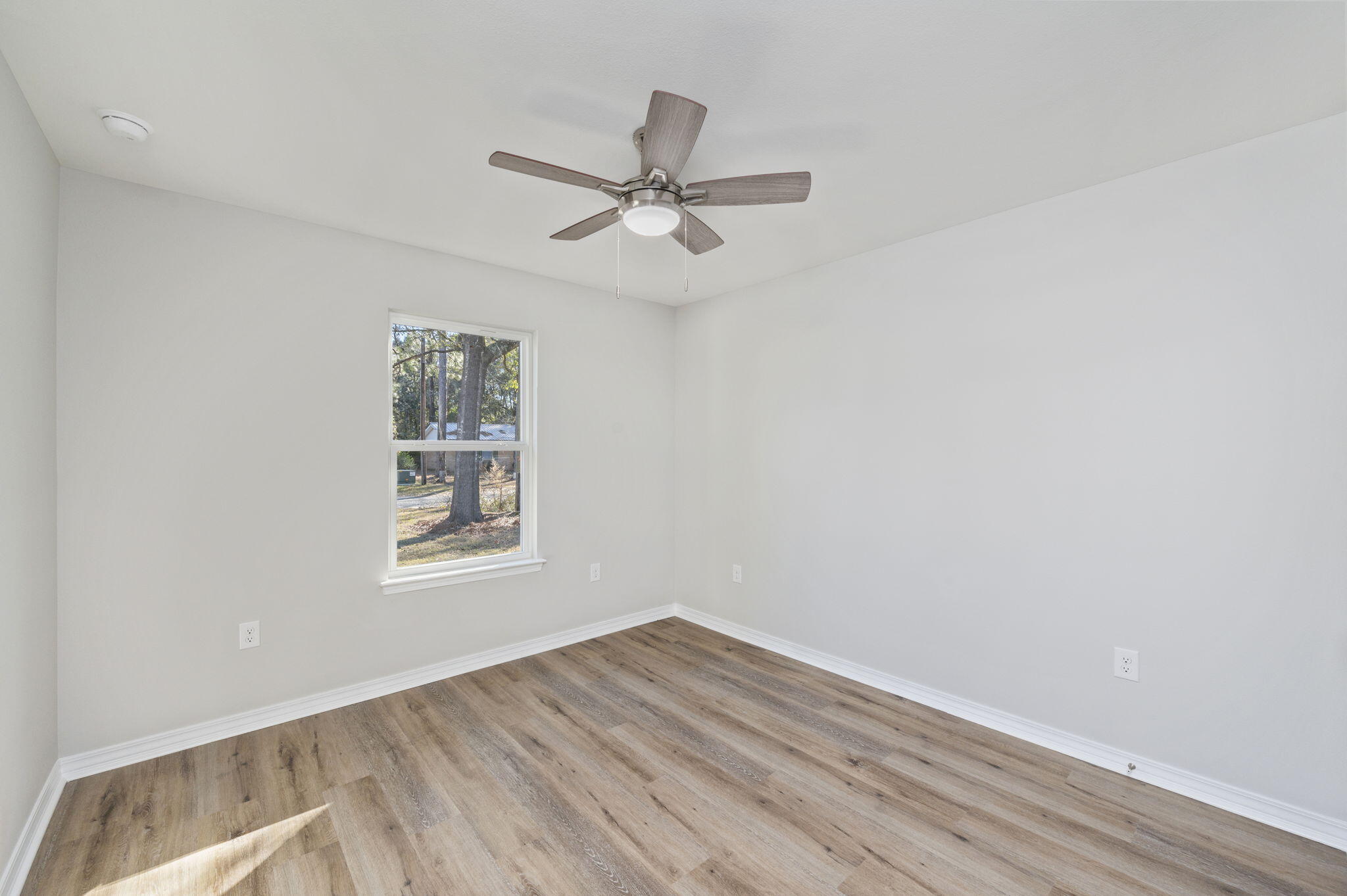 5362 Cox Lane Crestview, FL 32539 - Photo 15 of 29 an empty room with wooden floor ceiling fan and windows