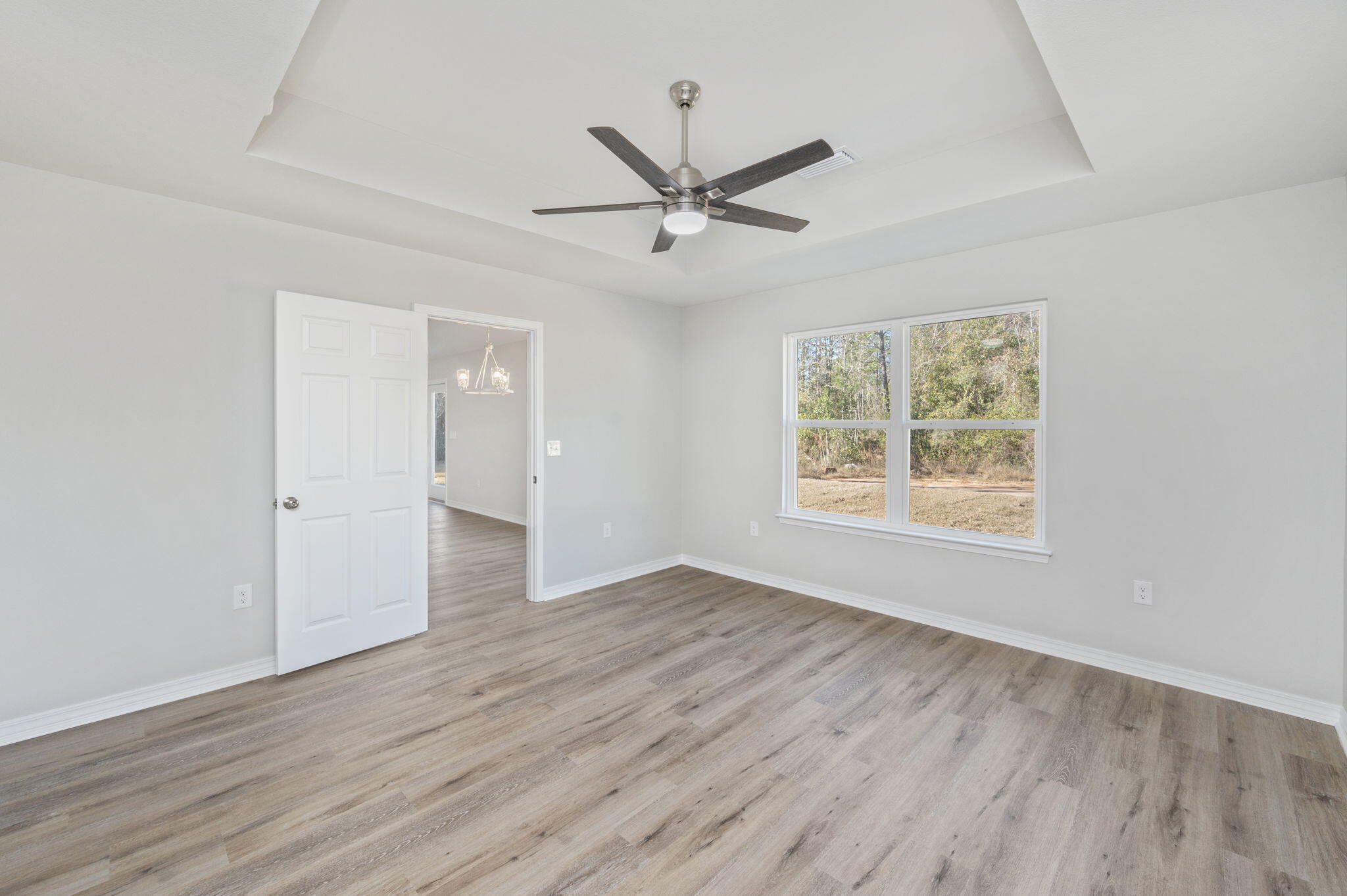 5362 Cox Lane Crestview, FL 32539 - Photo 20 of 29 an empty room with wooden floor a ceiling fan and windows