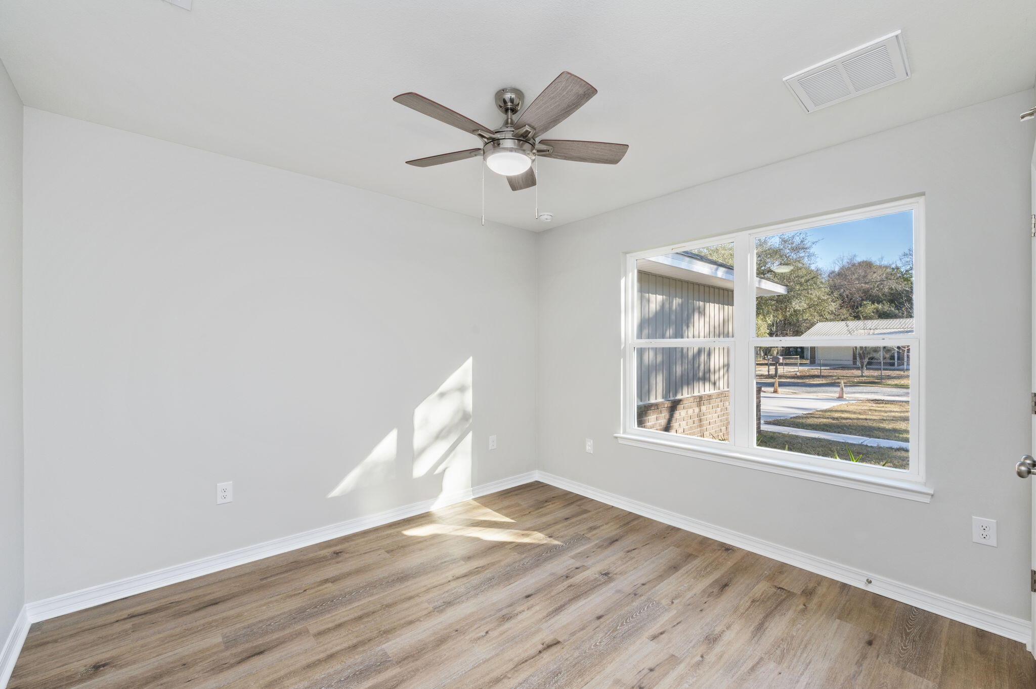 5362 Cox Lane Crestview, FL 32539 - Photo 25 of 29 a view of empty room with wooden floor and fan