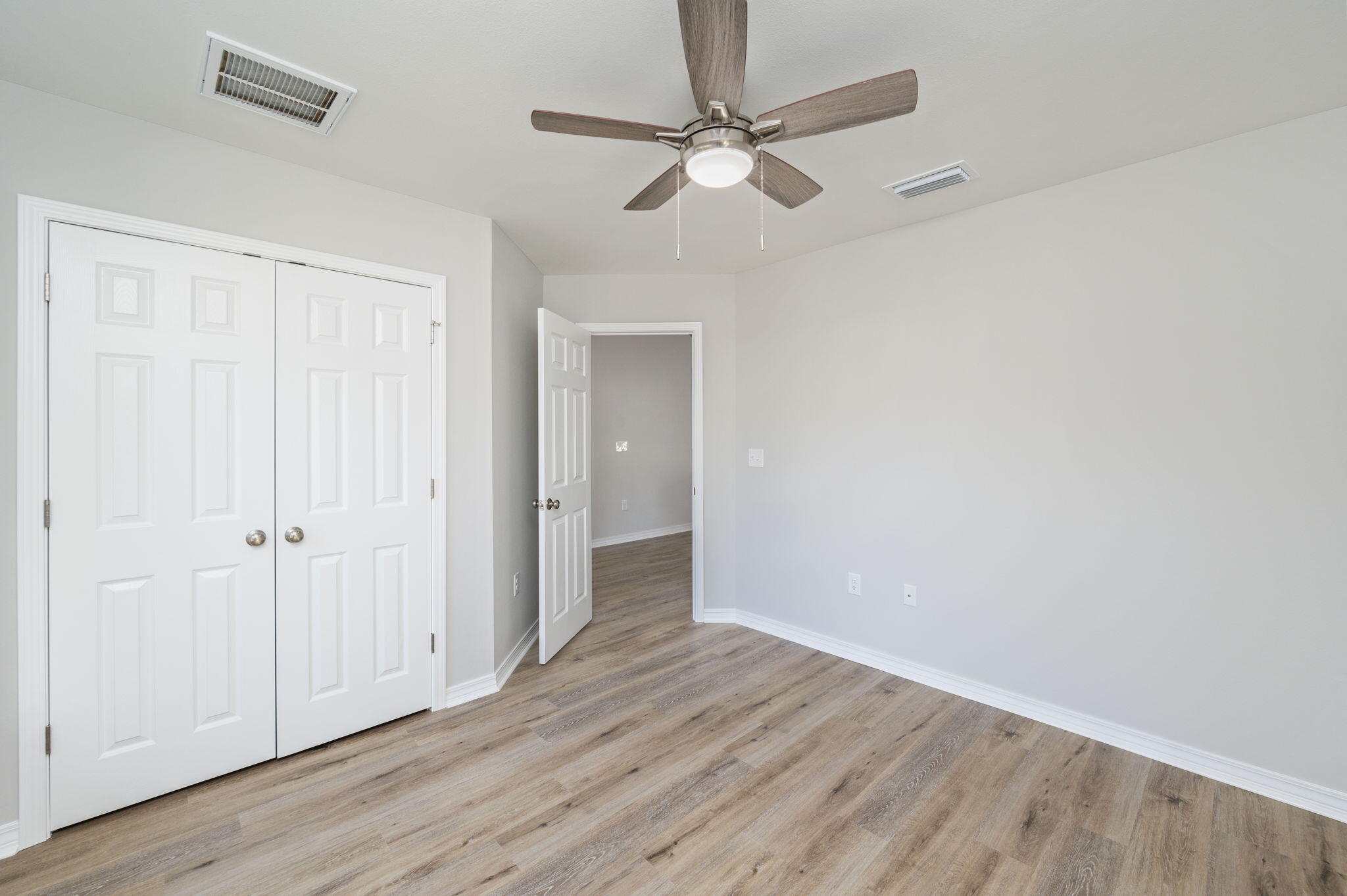 5362 Cox Lane Crestview, FL 32539 - Photo 26 of 29 an empty room with wooden floor fan and windows