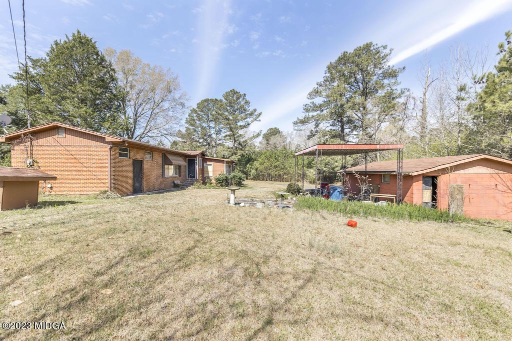 7369 Thomaston Road Macon, GA 31220 - Photo 18 of 25 a backyard of a house with table and chairs under an umbrella