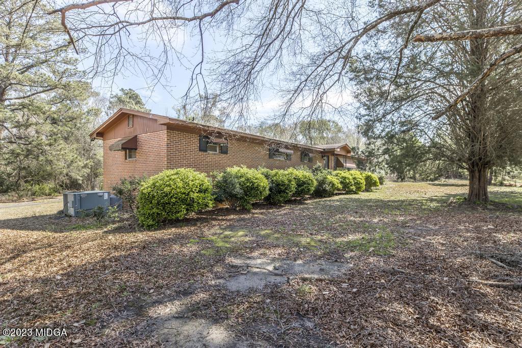 7369 Thomaston Road Macon, GA 31220 - Photo 6 of 25 a backyard of a house with large trees and outdoor seating