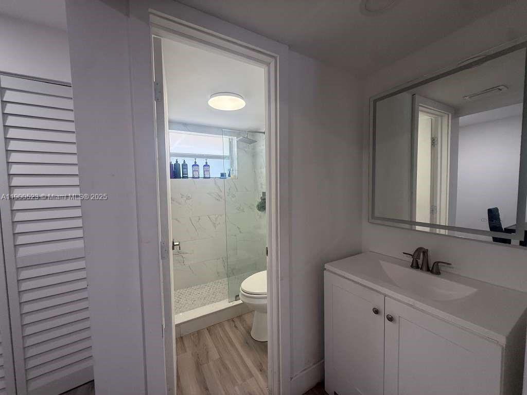 18900 Northeast 3rd Court, Unit 509 Miami, FL 33179 - Photo 4 of 19 a bathroom with a toilet a sink a mirror and vanity