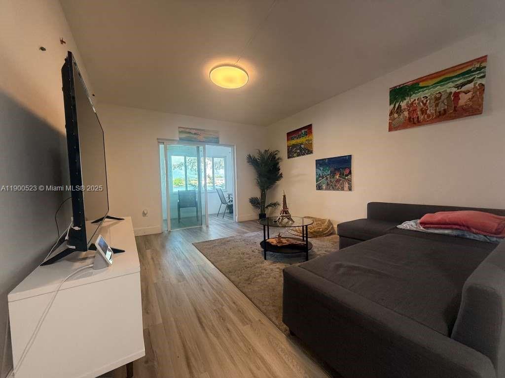 18900 Northeast 3rd Court, Unit 509 Miami, FL 33179 - Photo 7 of 19 a living room with furniture and a flat screen tv