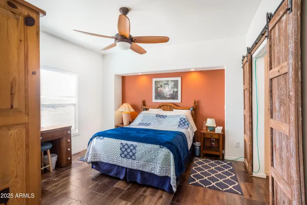 a bedroom with a bed and wooden floor