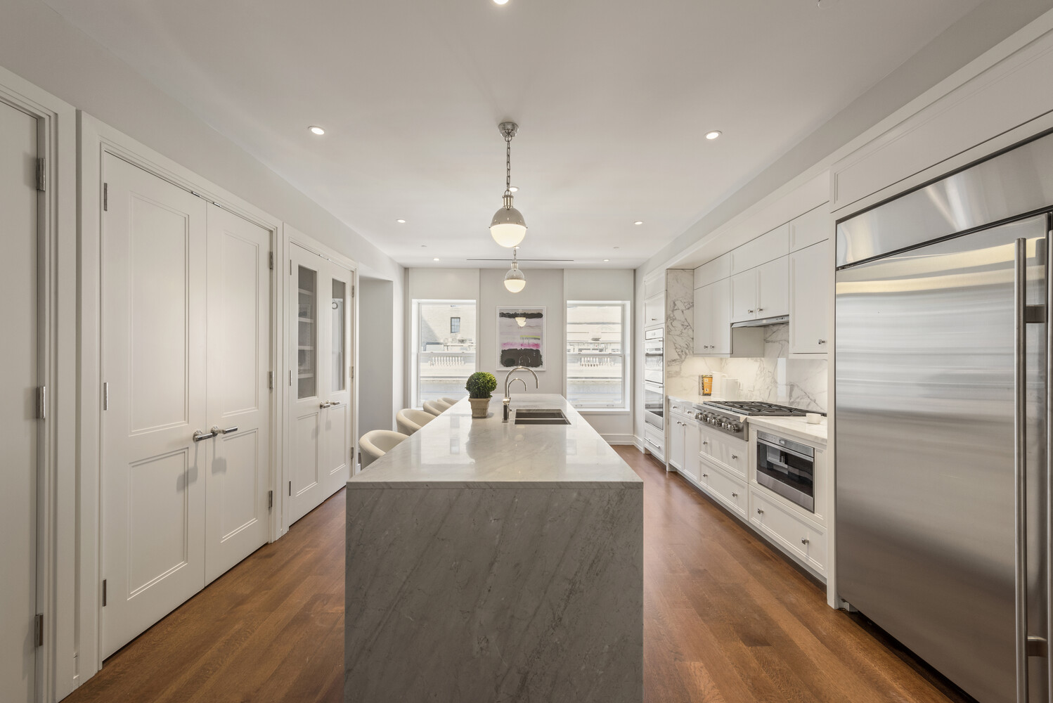 a large kitchen with kitchen island a large counter top space a sink stainless steel appliances and cabinets
