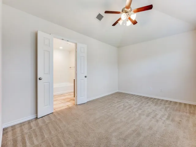 an empty room with closet and a chandelier fan