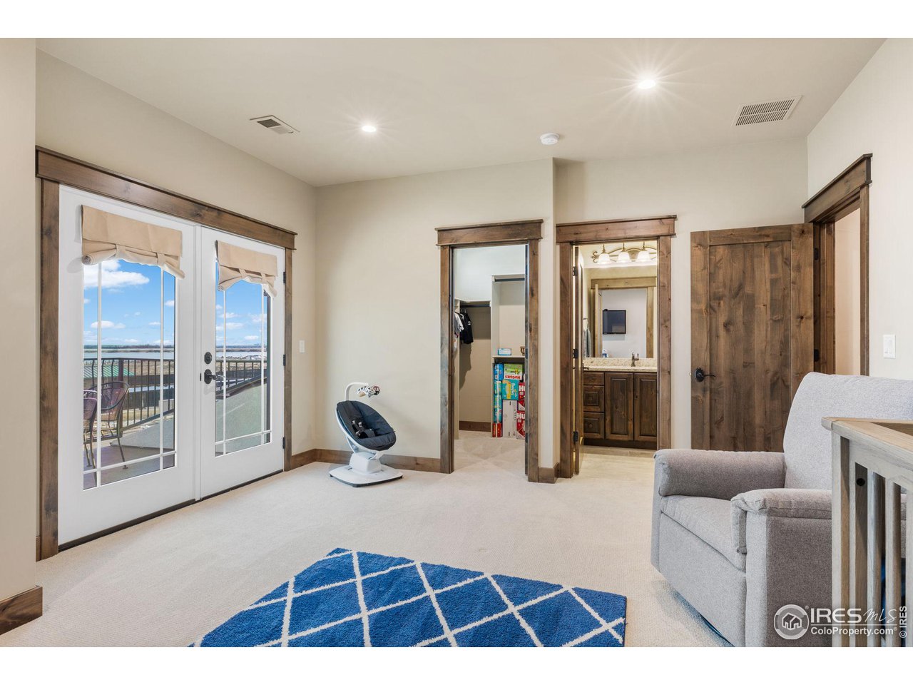2770 Heron Lakes Parkway Berthoud, CO 80513 - Photo 32 of 40 a living room with furniture a rug and glass windows