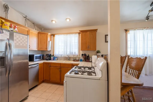 a kitchen with stainless steel appliances granite countertop a refrigerator a stove and a refrigerator