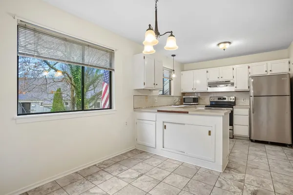 a kitchen with stainless steel appliances granite countertop a refrigerator a sink a stove and white cabinets