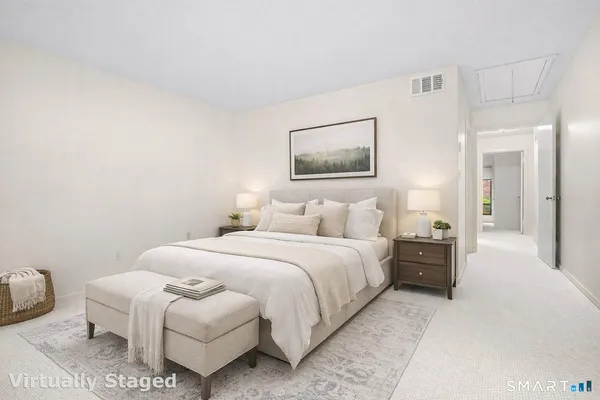 a bedroom with a bed and a painting on the wall