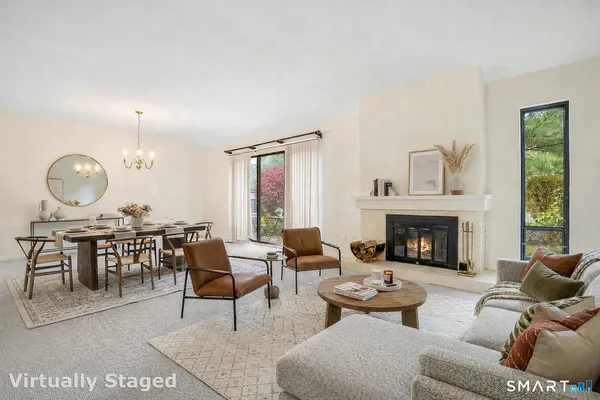 a living room with furniture a fireplace and a large window