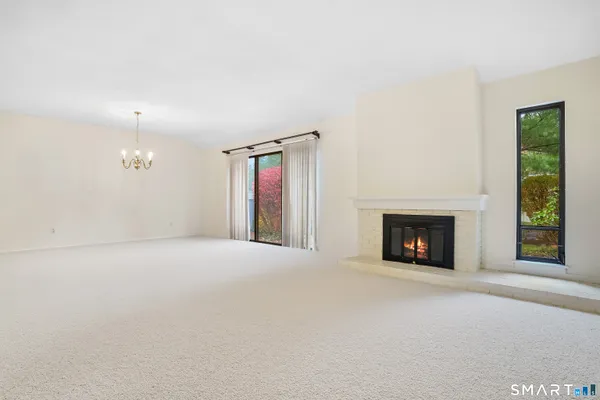 an empty room with windows and fireplace