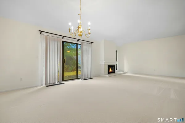 an empty room with fireplace and windows