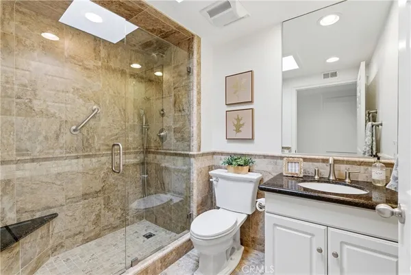 a bathroom with a sink toilet vanity and shower