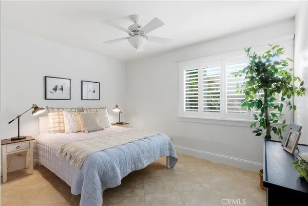 a bedroom with a large bed and a potted plant