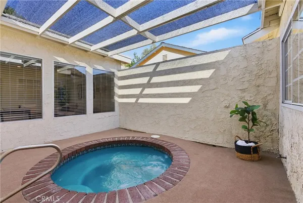 a view of a patio with table and chairs potted plants with floor to ceiling window