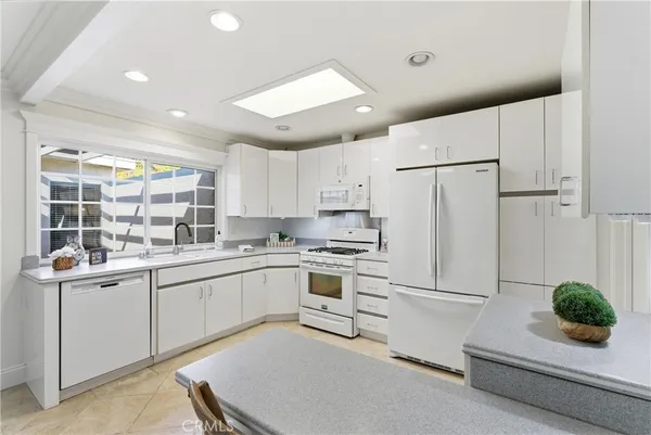 a kitchen with white cabinets and white appliances