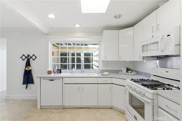 a kitchen with white cabinets and white appliances