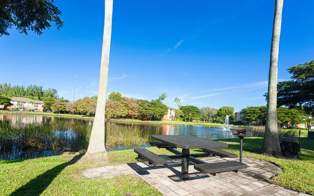 a view of a lake with a bench in a garden