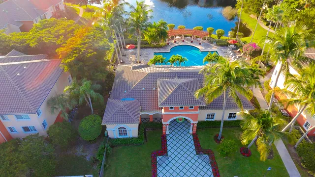 a aerial view of a house with swimming pool and large trees