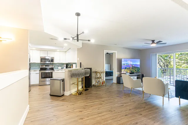 a living room with furniture a dining table and chairs with wooden floor