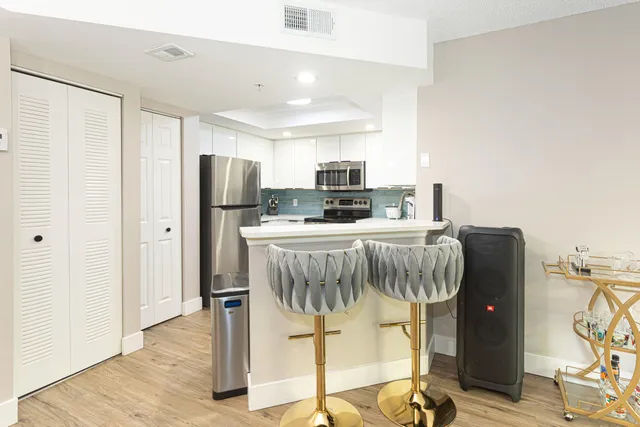 a kitchen with stainless steel appliances granite countertop a refrigerator and a stove top oven