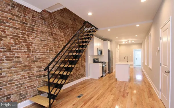 a view of a hallway with wooden floor and staircase