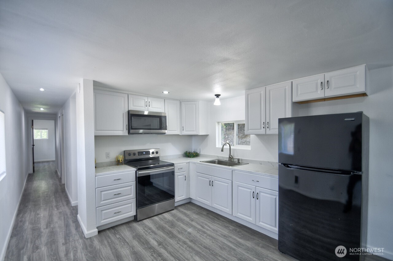 15503 Cedar Park Road Southeast, Unit 35C Olalla, WA 98359 - Photo 2 of 13 a kitchen with granite countertop a refrigerator stove top oven and sink