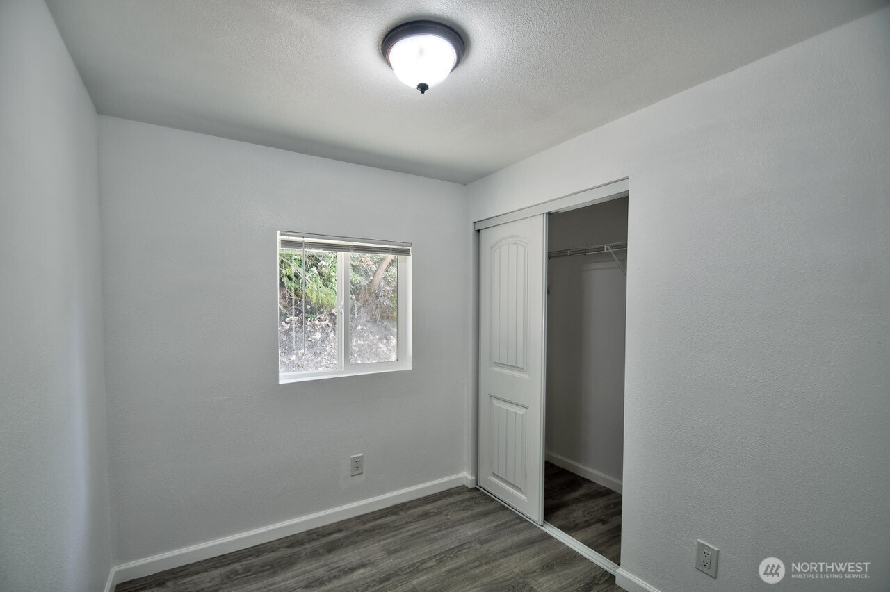 15503 Cedar Park Road Southeast, Unit 35C Olalla, WA 98359 - Photo 7 of 13 an empty room with wooden floor and window