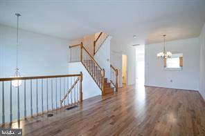 6348 Dakine Circle Springfield, VA 22150 - Photo 5 of 35 a view of staircase with wooden floor and pendant lights