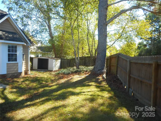 a view of a house with backyard and tree