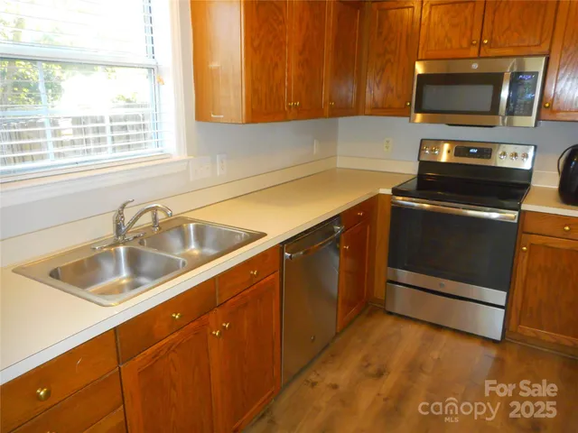 a kitchen with a sink a stove and microwave