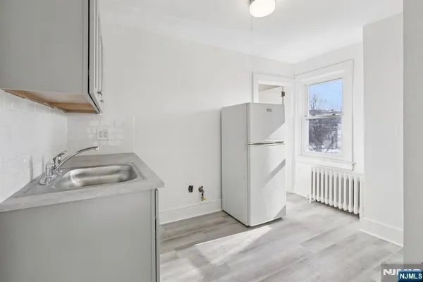 a kitchen with a refrigerator sink and cabinets