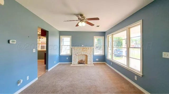 a view of a livingroom with a fireplace and windows