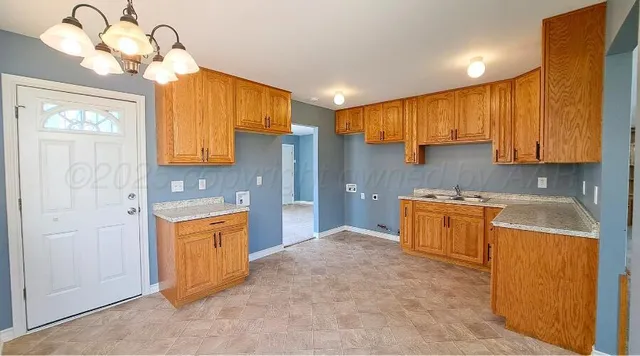 a kitchen with stainless steel appliances granite countertop a sink a stove cabinets and wooden floor