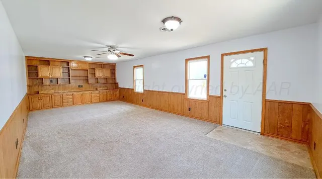 an empty room with a window and a fan