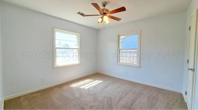 an empty room with windows and fan