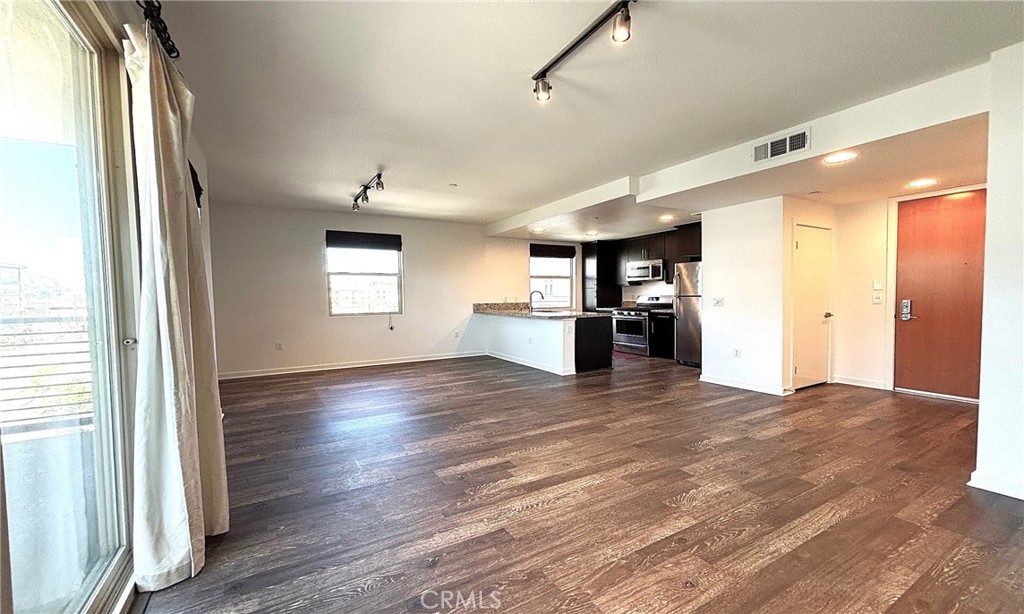 612 East Carson Street, Unit 303 Carson, CA 90745 - Photo 11 of 51 a view of a kitchen with wooden floor and a refrigerator