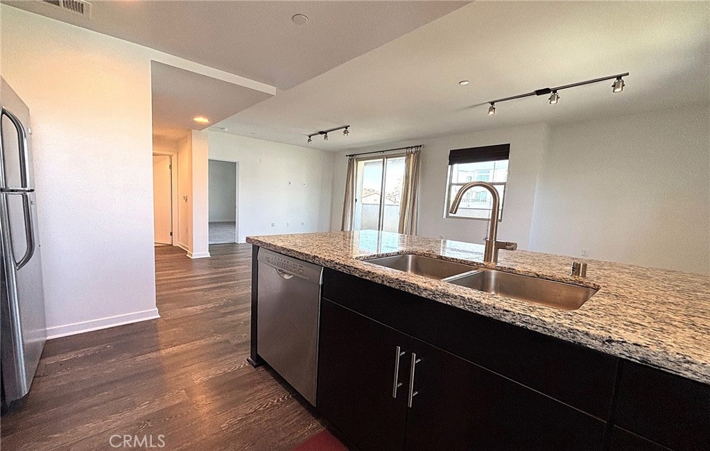 612 East Carson Street, Unit 303 Carson, CA 90745 - Photo 14 of 51 a kitchen with granite countertop a sink and a wooden floor