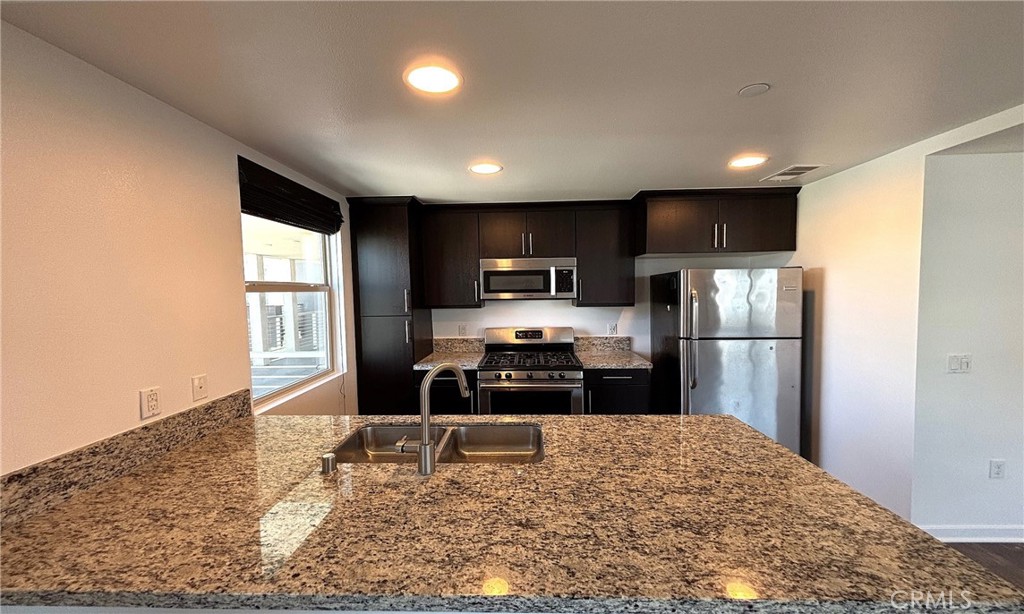 612 East Carson Street, Unit 303 Carson, CA 90745 - Photo 16 of 51 a kitchen with a refrigerator a stove top oven a sink and dishwasher