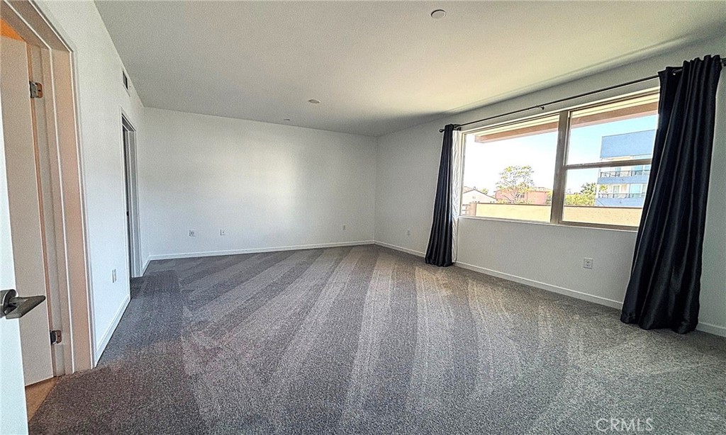 612 East Carson Street, Unit 303 Carson, CA 90745 - Photo 17 of 51 an empty room with wooden floor and windows